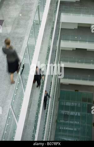 Businesspeople walking through office building Stock Photo