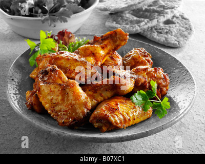 Barbeque (BBQ) Chicken wings served on a plate in a table setting. Stock Photo