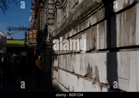 a man walking alongside a wall next to the natural history museum in london Stock Photo