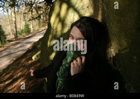 a portrait of a beautiful woman in nice light holding a scarf up over her face Stock Photo