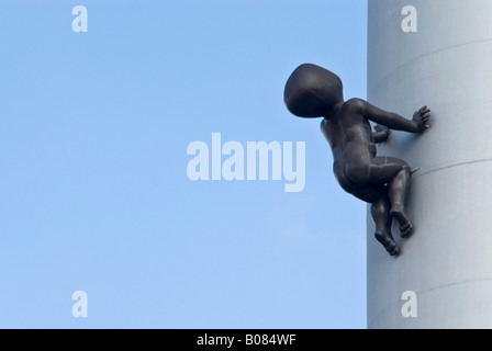 Horizontal close up of David Cerny's Miminka 'Crawling Babies' on the Zizkov Television Tower against a bright blue sky. Stock Photo