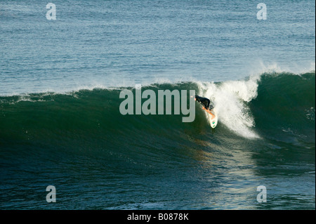 A surfer rides the crest of a wave Stock Photo