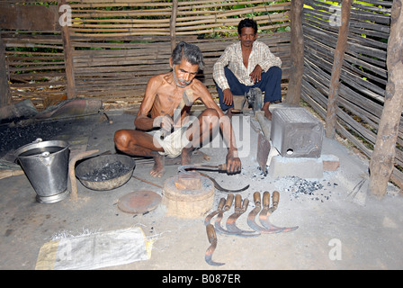 Blacksmith is busy making tools in his workshop. Warli tribe, Thane, Maharashtra, India Stock Photo