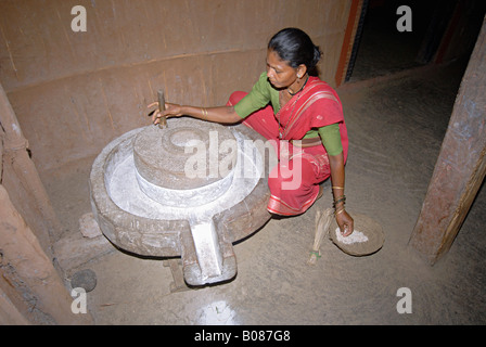 Warli Tribal women Grinding rice. Stock Photo