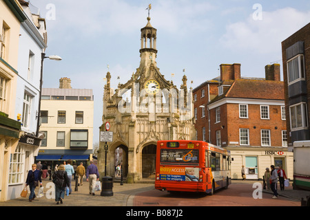 City centre with people and a red local bus passing old Market Cross circa 1501 at junction. West Street Chichester West Sussex England UK Britain Stock Photo