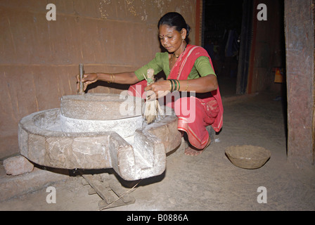 Warli Tribal women Grinding rice. Stock Photo