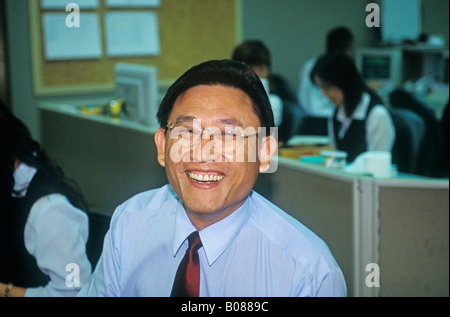 Asian Chinese Man Smiling At Work Stock Photo