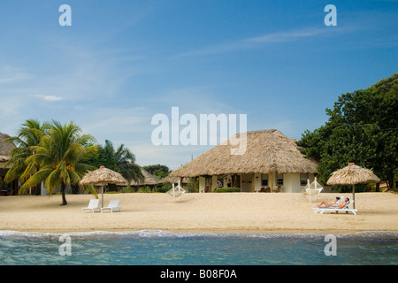 Thatched palapas, cabana and lounge chairs on beach, viewed from Caribbean Sea, Jaguar Reef Lodge, Hopkins, Stann Creek District Stock Photo