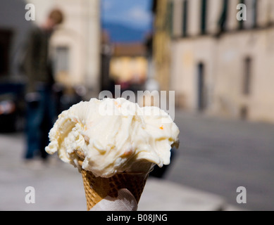 an Italian ice cream cone with blurred Tuscan street of Lucca in background Stock Photo