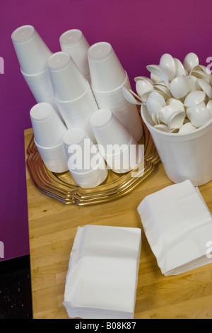 Styrofoam cups plastic spoons and paper napkins laying on a wooden table Location Released Stock Photo