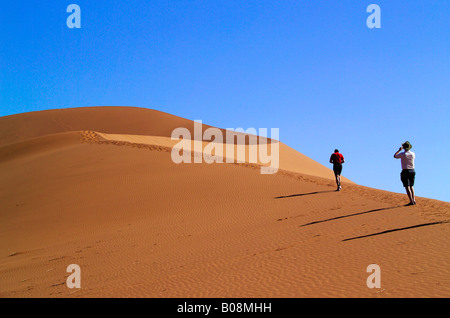 People climbing up the Big Mama, second-largest sand dune in the Sossusvlei, Namibia, Africa Stock Photo