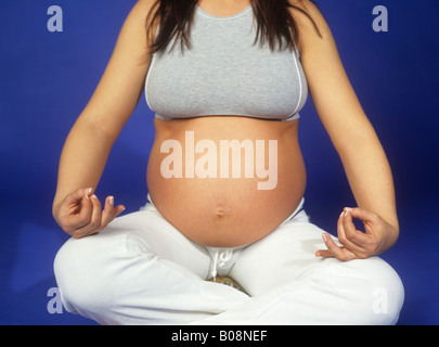 Pregnant woman practicing yoga Stock Photo