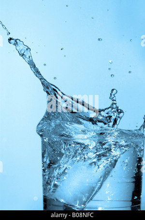 ice cube falls into water glass Stock Photo - Alamy