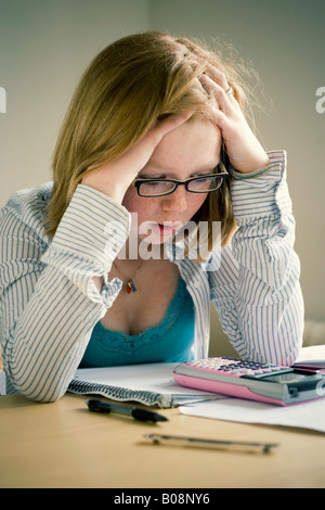 Schoolgirl doing homework, thinking, getting frustrated Stock Photo