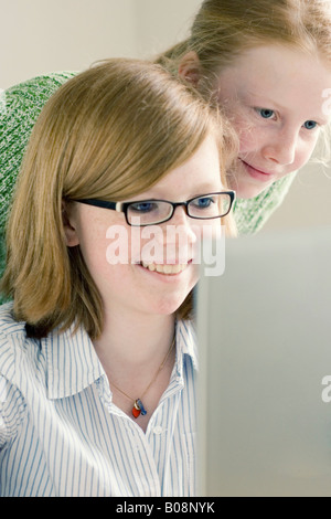 Two girls sitting in front of a computer Stock Photo