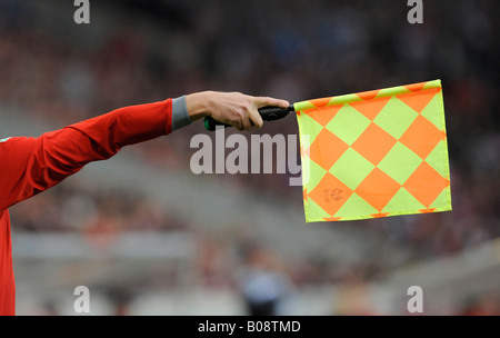 Assistant referee at a football match showing flag, offside position Stock Photo