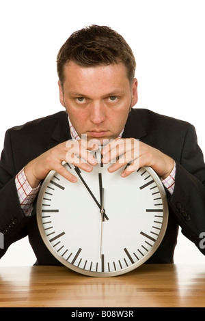 40-year-old businessman leaning on a clock, time is 5 to 12 Stock Photo