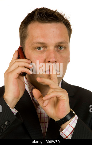 40-year-old businessman talking on the phone, asking for silence, shh gesture Stock Photo