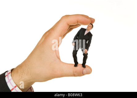 Hand holding a businessman between its fingers Stock Photo