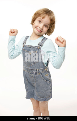 Dark-blonde, 8-year-old girl acting goofy, winner's pose Stock Photo