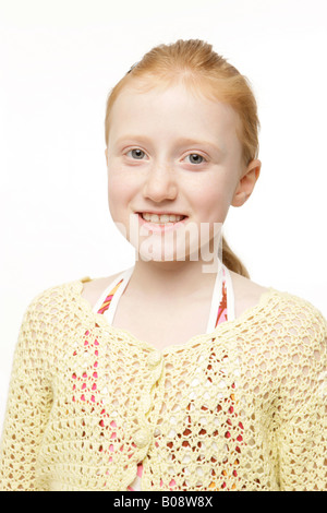 Redheaded 8-year-old girl wearing a yellow knit sweater, jumper Stock Photo