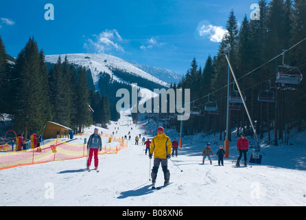 Skiers skiing down the Lukova ski run, Jasna Ski Resort, Lower Tatras, Slovakia Stock Photo