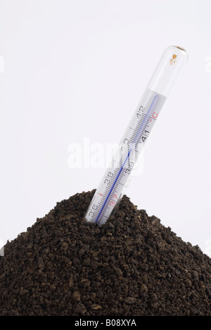 Thermometer in a pile of soil, symbolic for global warming