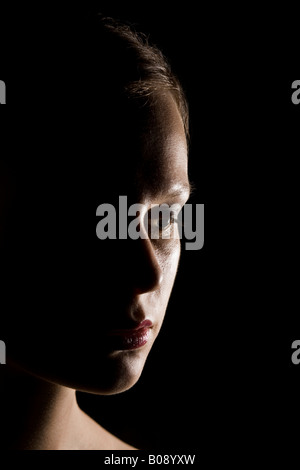 Portrait of a young woman, strong side lighting, shadow Stock Photo