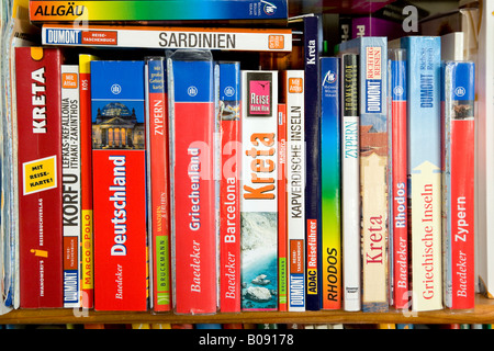 Various travel guides on a bookshelf Stock Photo
