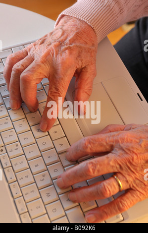 Elderly hands on a laptop keyboard Stock Photo
