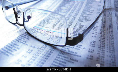 glasses lying on newspaper with stock quotations Stock Photo