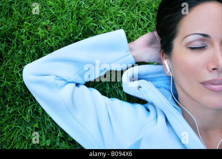 Woman lying on the grass and listening to music