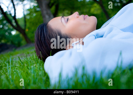 Woman lying on the grass and listening to music