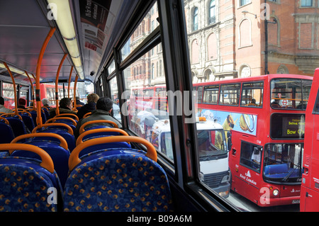 Back view people in bus interior top deck of transport for London tfl red public passenger transport double decker buses view out of window England UK Stock Photo