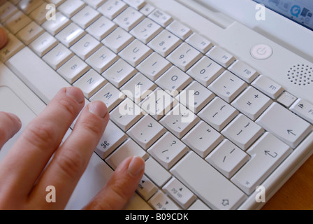 Hands typing on an Apple iMac notebook keypad Stock Photo