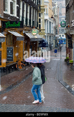 Amsterdam, Bars and people in Torensteeg street in falling snow Stock Photo