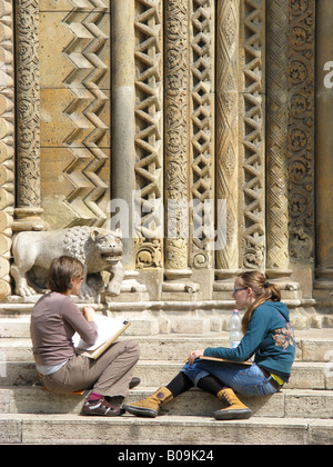 HUNGARY, BUDAPEST. Girls sketching at a 19th century replica of the chapel in Jak at Vajdahunyad Castle in the Varosliget. Stock Photo