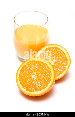 Glass of freshly squeezed orange juice with a halved orange, isolated on a white studio background. Stock Photo