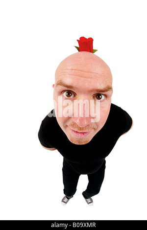bald headed man hinding a red rose behind his back Stock Photo