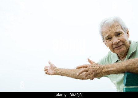 Senior man with arms out, furrowing brow, looking at camera Stock Photo