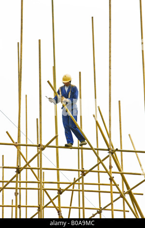 Man in hard hat assembling scaffolding Stock Photo