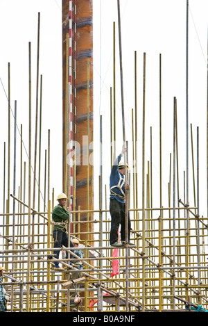 Construction workers on standing on scaffolding, low angle view Stock Photo