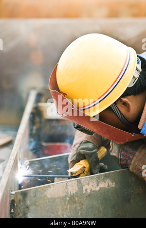 Worker welding metal, side view, close-up Stock Photo