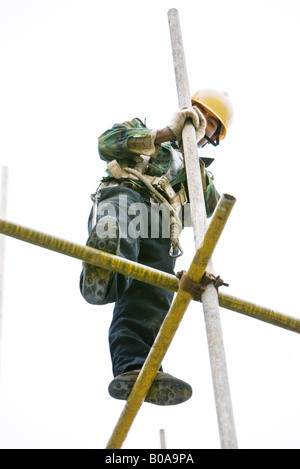 Construction worker standing on scaffolding, low angle view Stock Photo