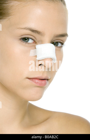 Woman with bandaged nose, looking at camera, close-up Stock Photo