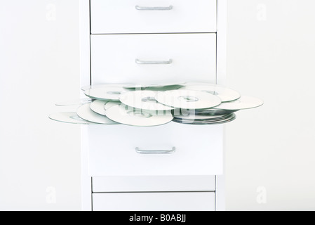 CDs spilling out of filing cabinet drawer Stock Photo