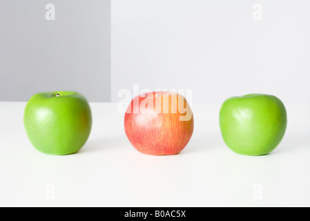 Three apples in a row, two green and one red, close-up Stock Photo