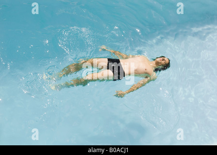 Man floating on back in swimming pool, high angle view Stock Photo