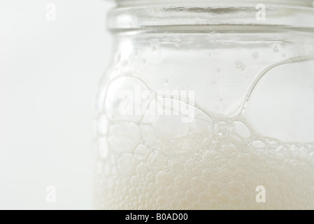 Glass jar with soap suds, extreme close-up