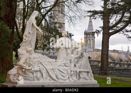 White marble statue in a park in Lourdes showing a healing miracle by the Virgin Mary, Lourdes, France. Stock Photo